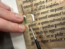 Applying a Japanese paper disc as a repair using wheat starch paste.