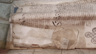 Paper and parchment with damaged seals, creases and ingrained dirt.
